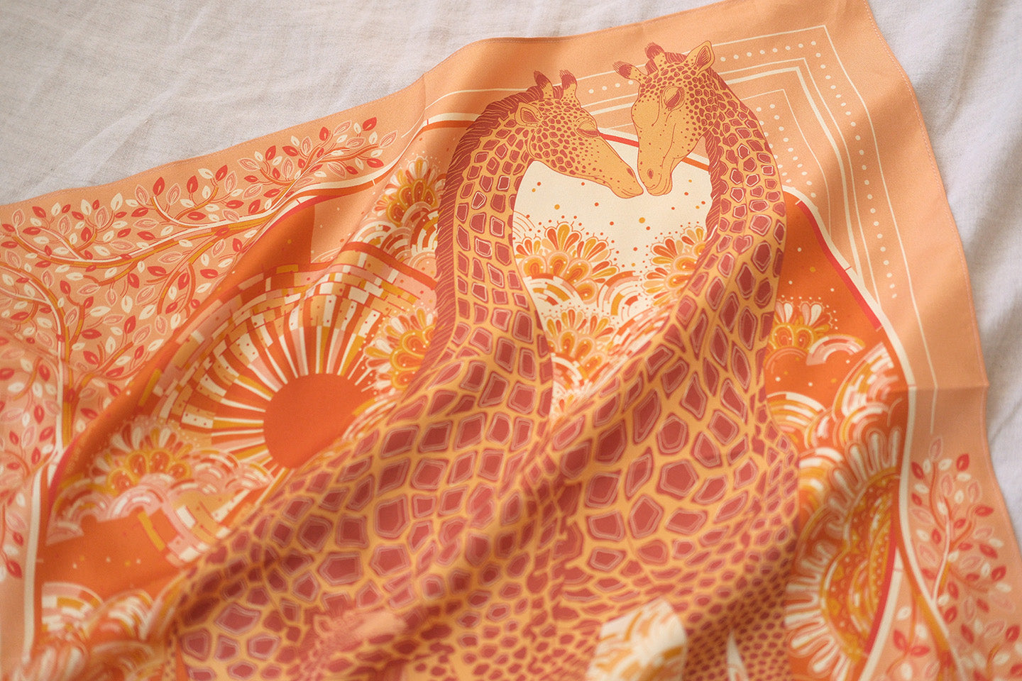 Orange scarf with intricate giraffe design on a light background