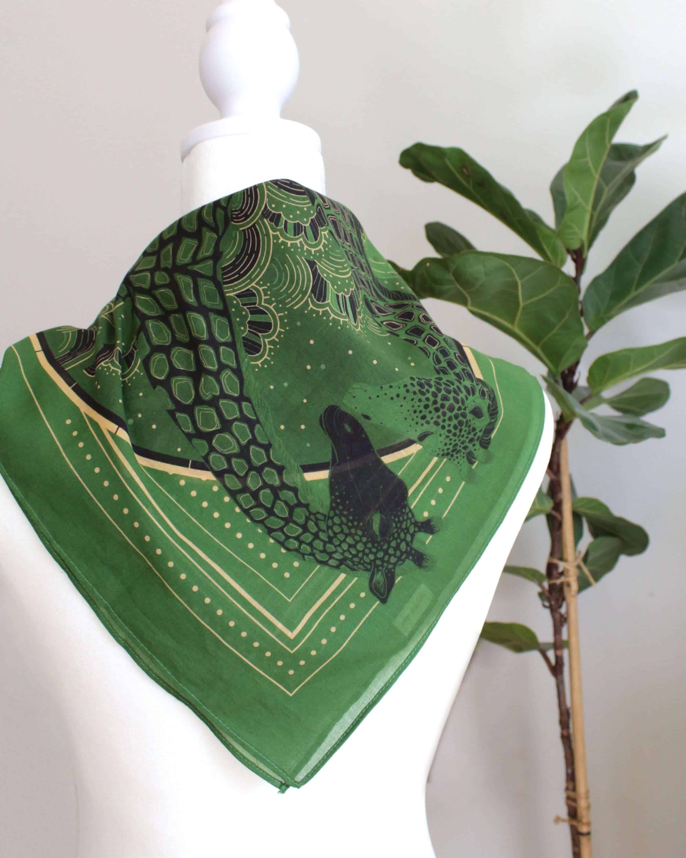 Olive green bandana scarf featuring a giraffe family design, perfect as a hair accessory or pet scarf.