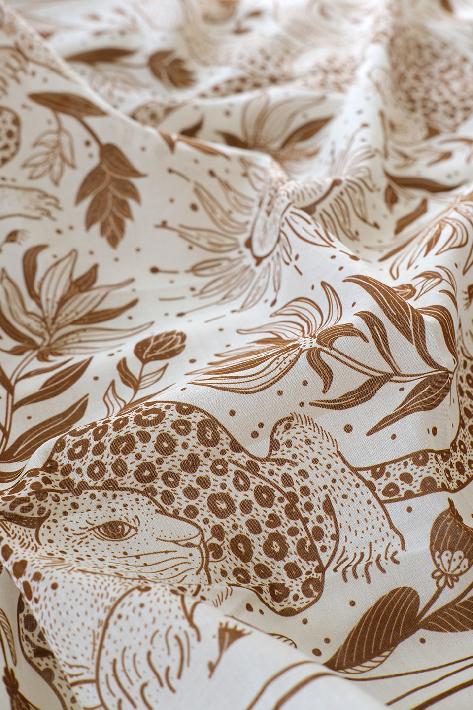 Close-up of off-white cotton scarf featuring leopard and floral line art design.