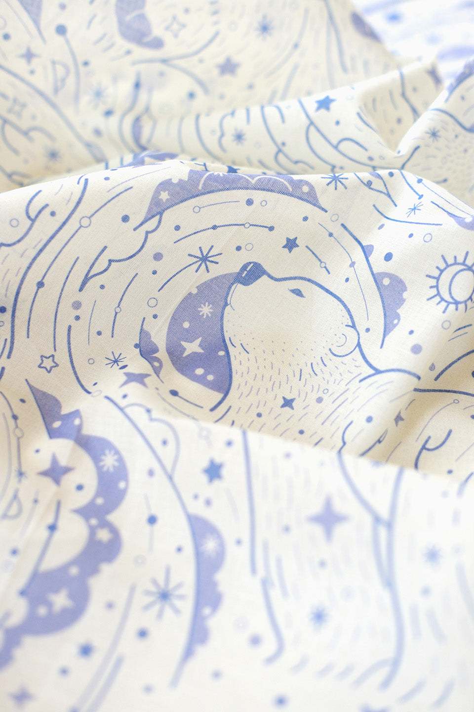 Close-up of Polar Bear and Northern Sky design on an off-white bandana scarf, featuring celestial patterns and soft colors.