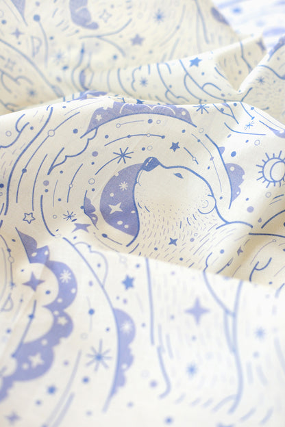 Close-up of Polar Bear and Northern Sky design on an off-white bandana scarf, featuring celestial patterns and soft colors.