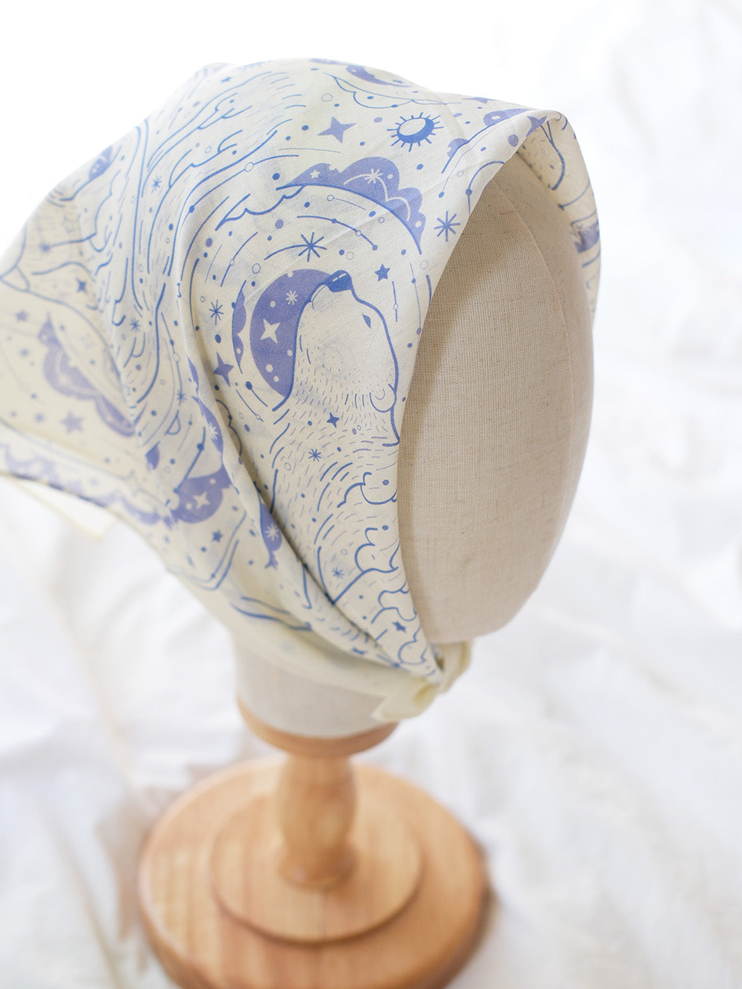 Off-white polar bear and northern sky bandana scarf displayed on a wooden mannequin head.