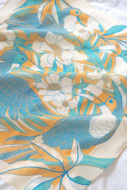 Toucan in a Floral Jungle Bandana Scarf featuring vibrant blue and yellow colors, perfect for accessories and decor.