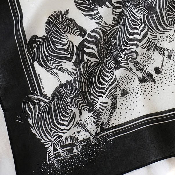 Black and white bandana scarf featuring a herd of zebras running, perfect as a hair accessory or decoration.