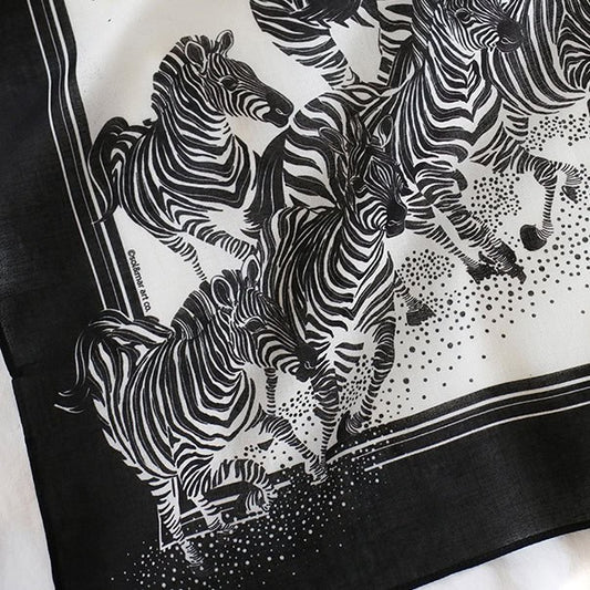 Black and white bandana scarf featuring a herd of zebras running, perfect as a hair accessory or decoration.
