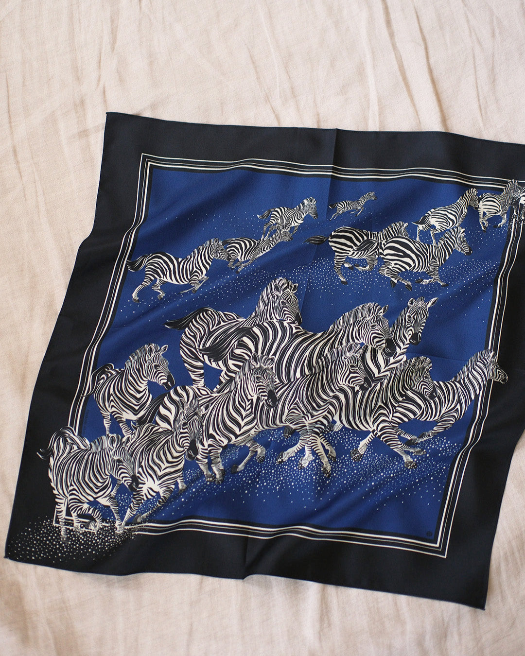 Blue scarf with zebra pattern on a beige surface