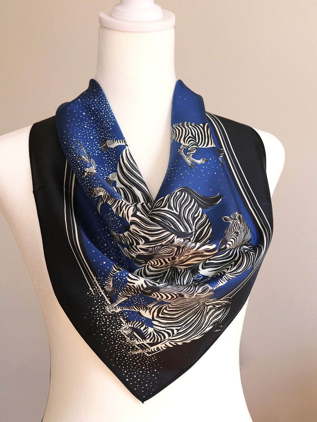 Blue scarf with zebra pattern on a mannequin against a beige background