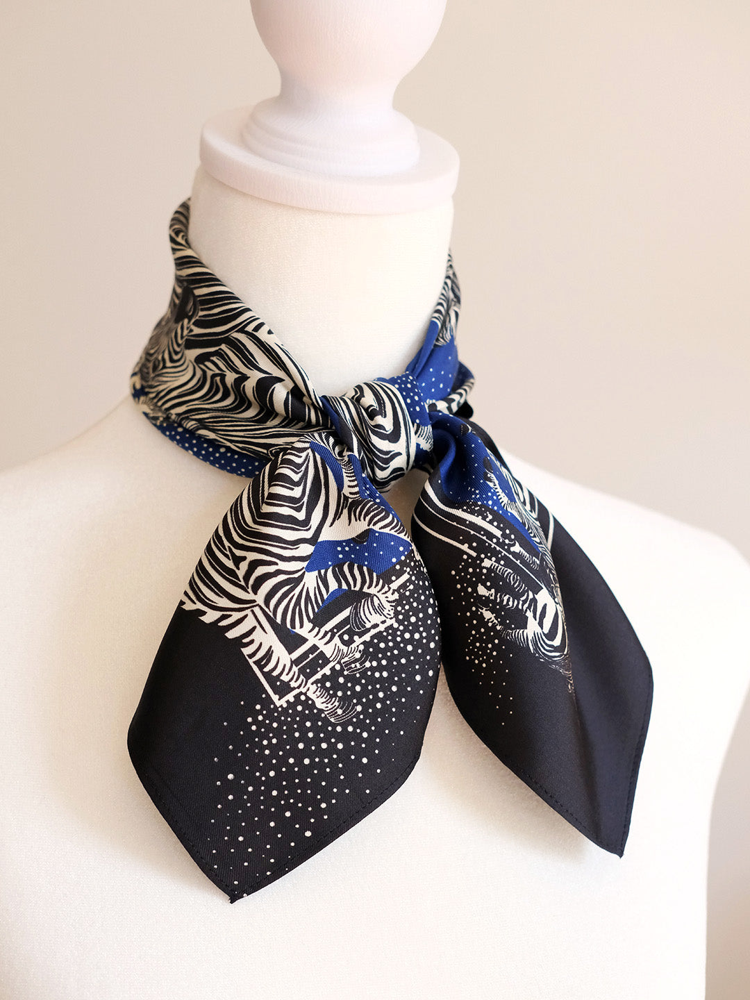 Mannequin wearing a black scarf with zebra print and blue accents