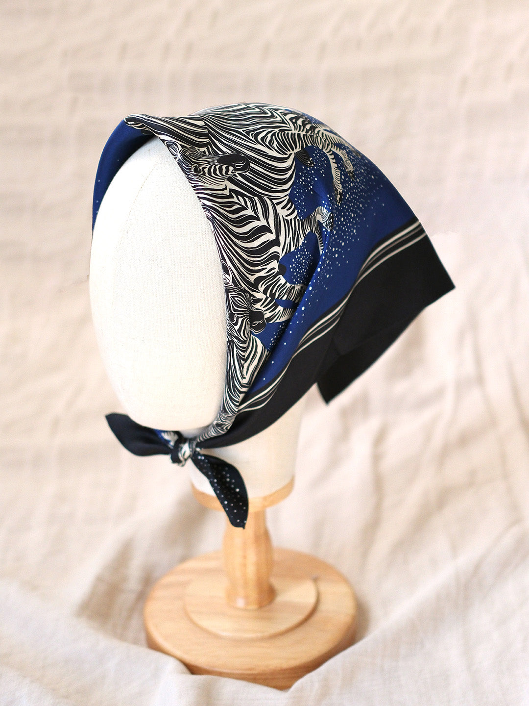 Zebra patterned headscarf on a mannequin head against a beige background